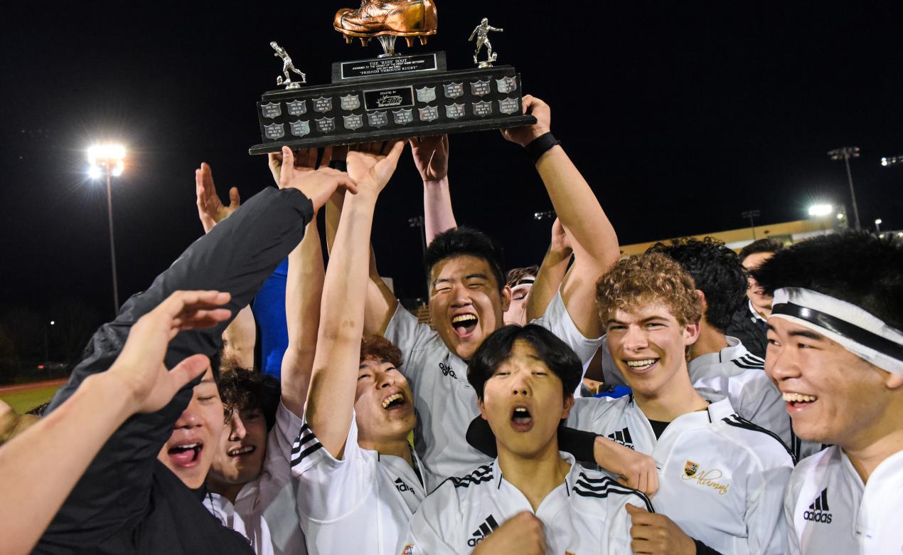 Senior Boys Rugby players lift the Boot Game trophy in celebration