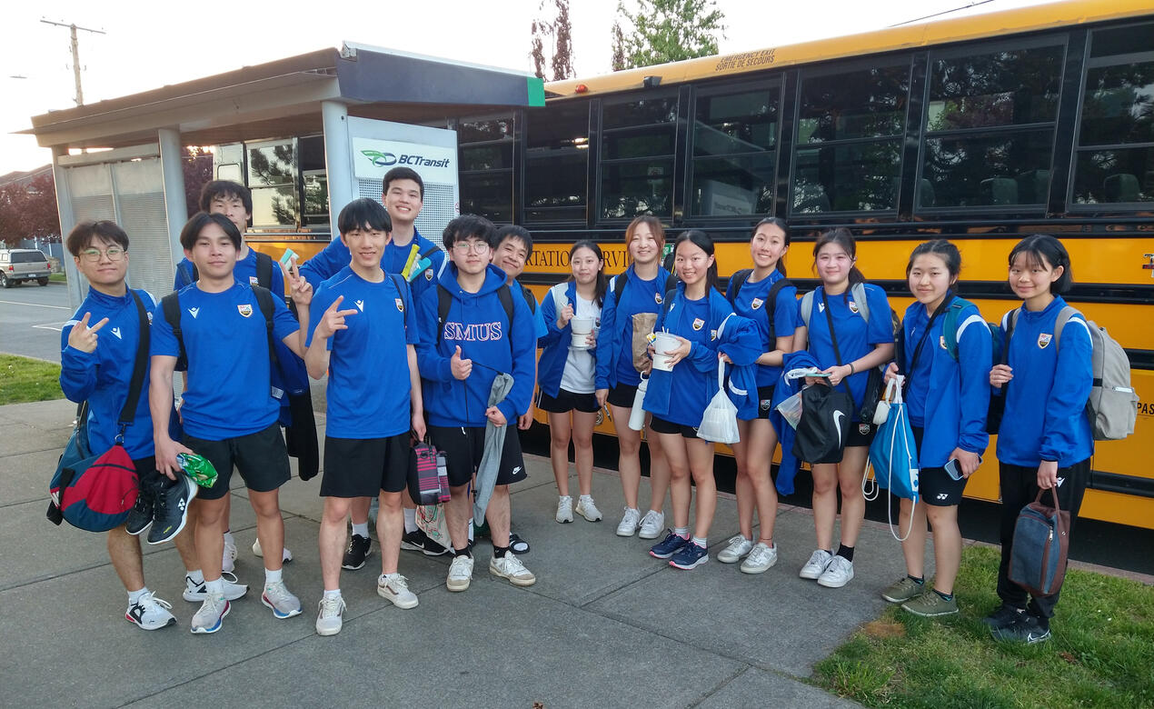 The SMUS Badminton team waiting to board the bus