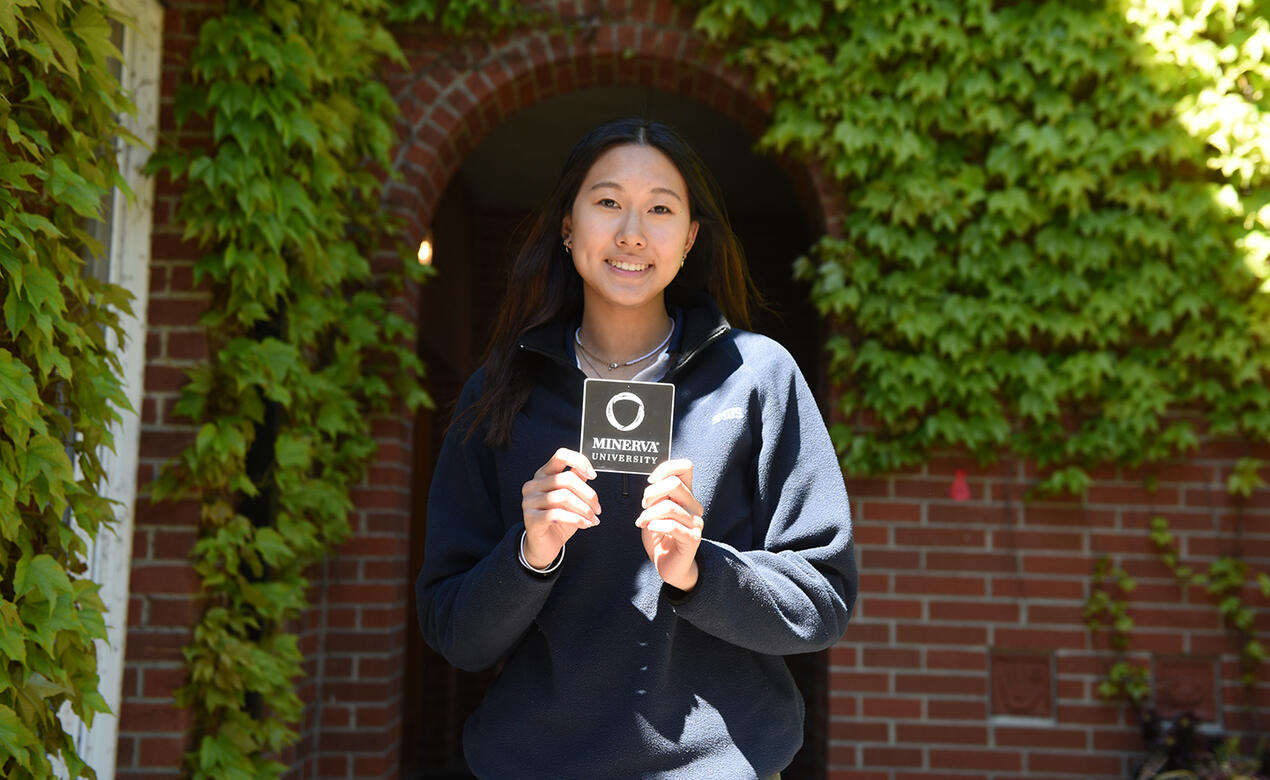 A student holds a Minerva sticker