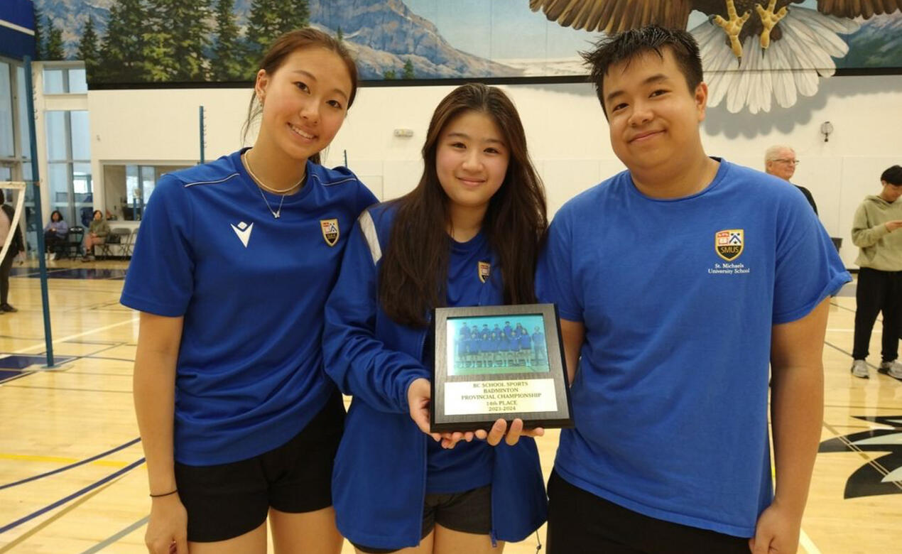 SMUS badminton players pose with a plaque