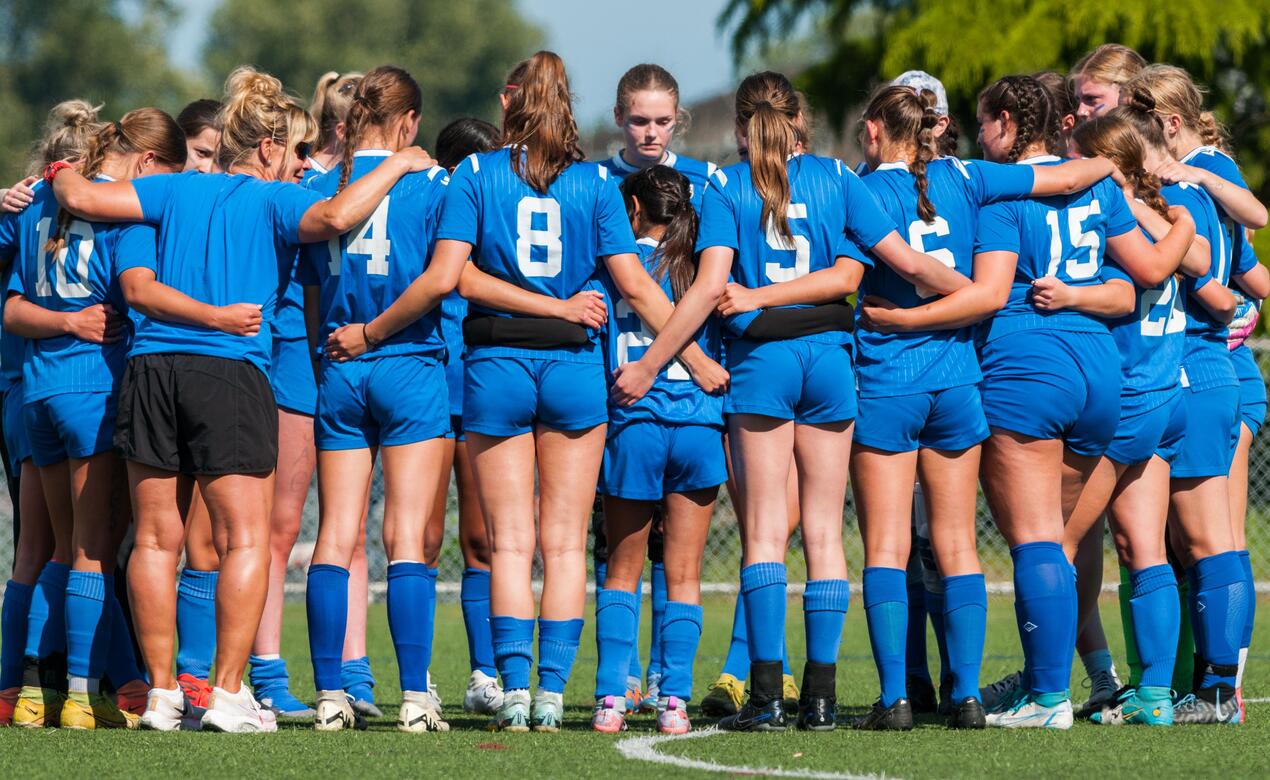 SMUS Senior soccer players huddle up together on the field