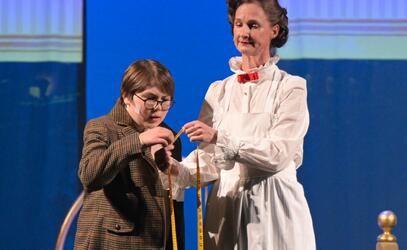 Levi Budd performs his character with a woman dressed in a white dress like Mary Poppins