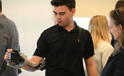 A Senior School student tests out a prosthetic arm device