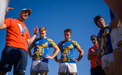 UVic Vikes men's rugby head coach gives advice to his team in a close team huddle