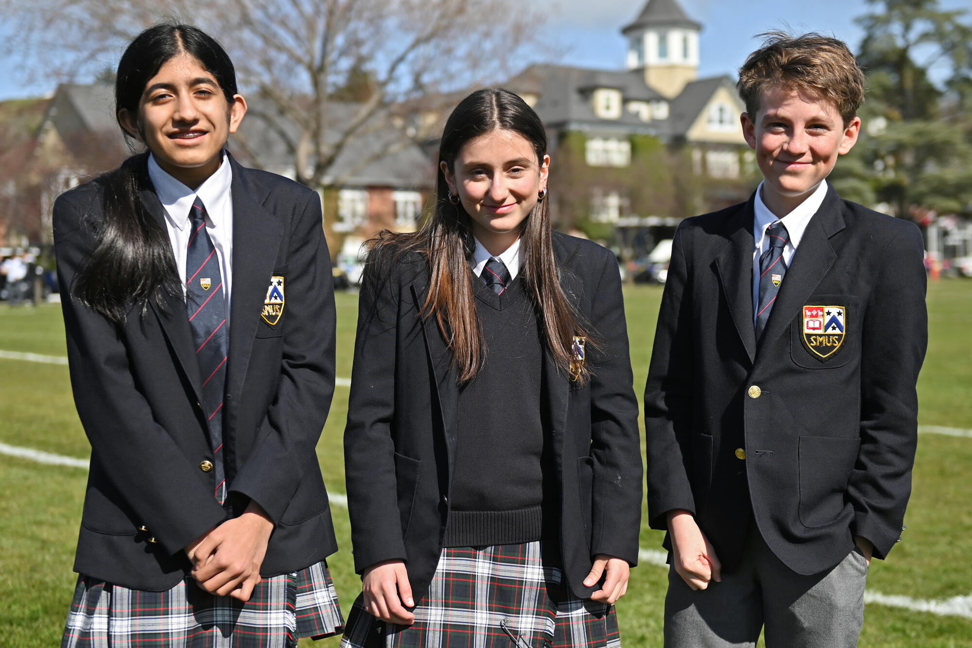 Grade 8 students Yashita, Bella and West, all athletes headed to the BC Winter Games, pose in front of SMUS