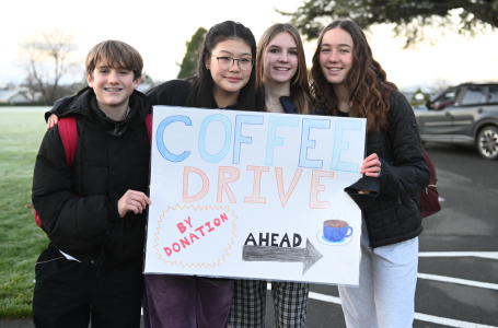 Senior School students hold a sign for the by-donation coffee drive through