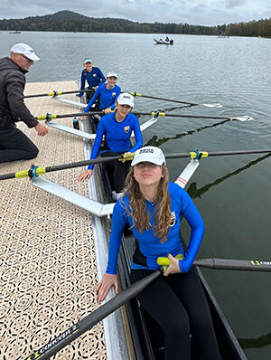 4 rowers prepare to leave the dock