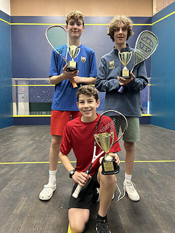 3 players with racquets hold their trophies